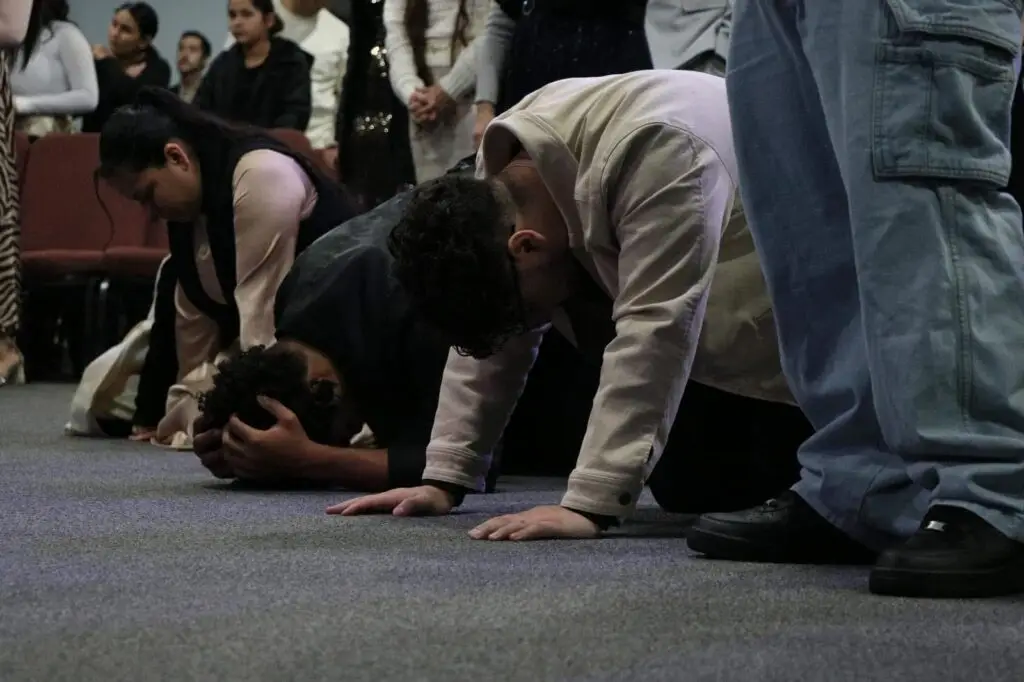 Fieles en la iglesia Firstborn Ministerios en Rockford, IL, en un profundo momento de oración y adoración, buscando la presencia de Dios.