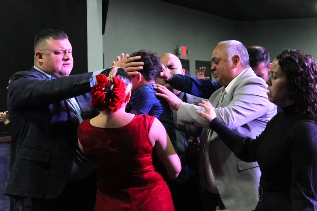 Momento de oración y bendición en la iglesia, donde líderes y miembros se unen en intercesión, reflejando fe, unidad y el poder de la comunidad cristiana.